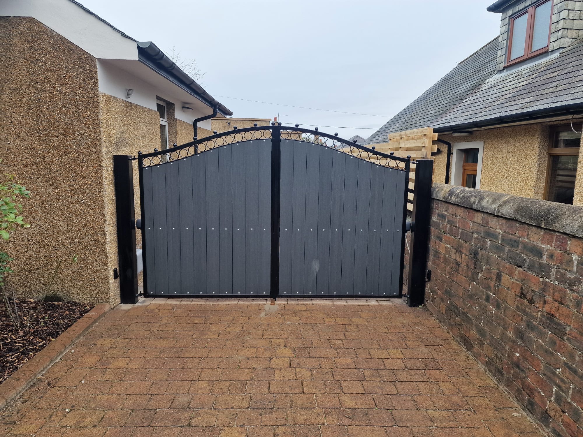 Arched composite driveway gates with circle ironwork